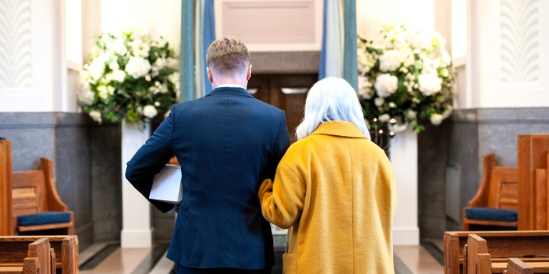 Sørgende mor og søn med urne i kirke