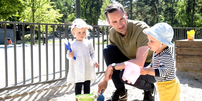 Børn på legeplads med mandlig pædagog