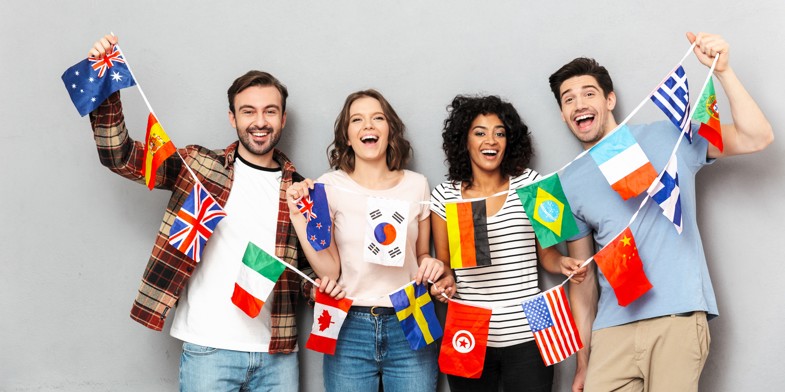 Personer med forskellige hudtoner og en snor med internationale flag