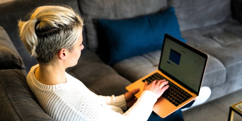 Kvinde arbejder hjemmefra med computer på skødet
