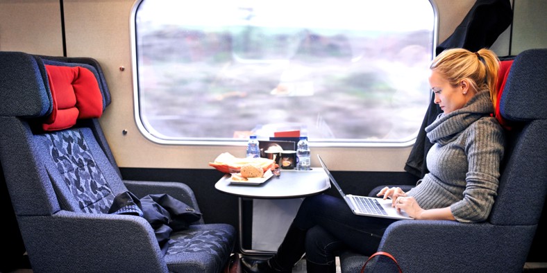 Woman working on a laptop during a train commute between Denmark and Sweden