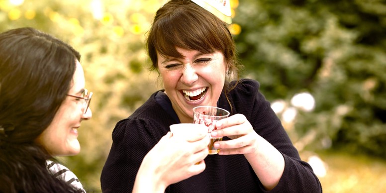 To kvinder griner og skåler til krebsegilde