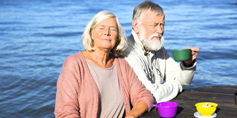 Pensionistpar drikker kaffe ved havet