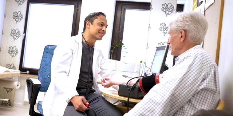 Mandlig læge taler med mandlig patient